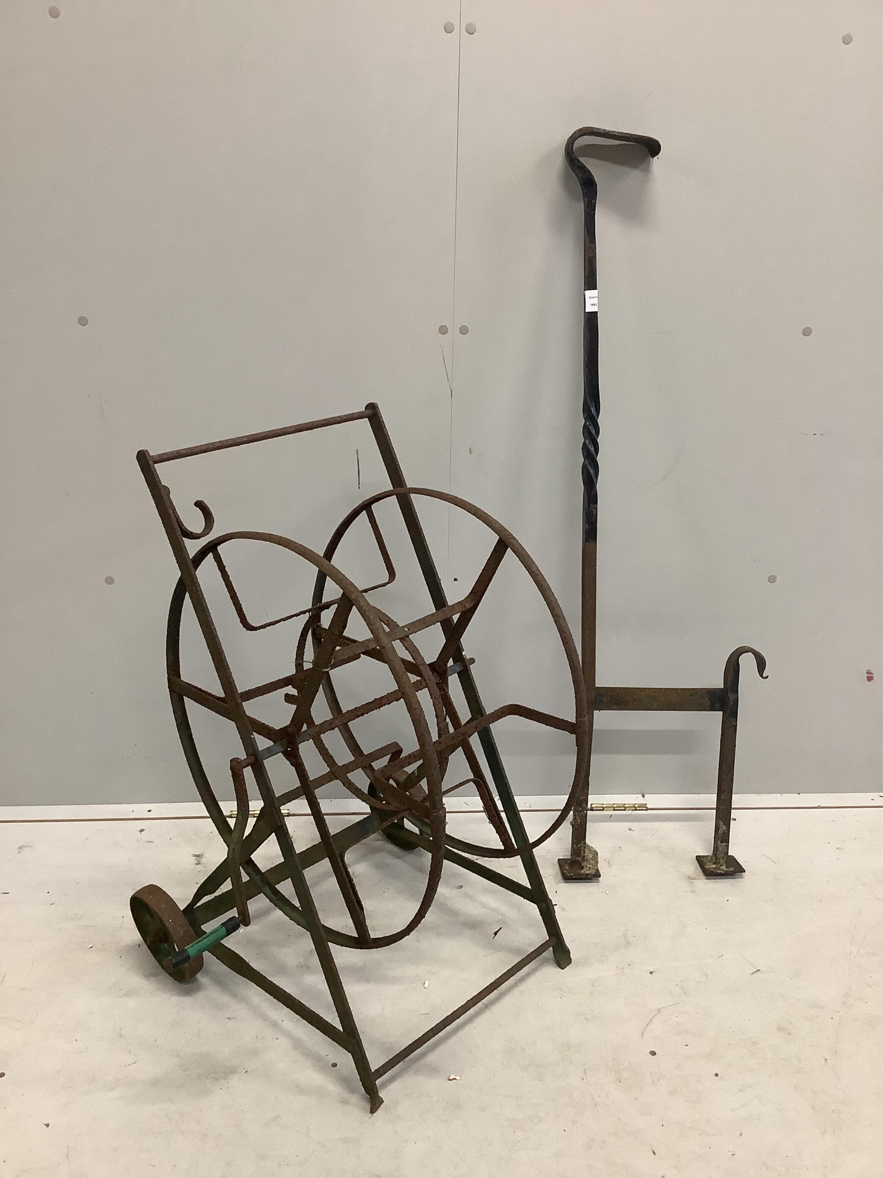 A wrought iron boot scraper, height 122cm together with a hose reel stand. Condition - poor to fair